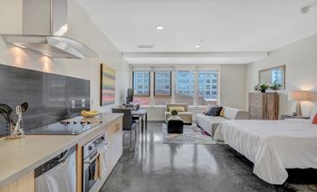 Modern kitchen with a large island and a bedroom with a large bed.